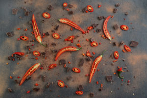 Rote Chilischoten mit Kakaopulver und Schokolade Rote Chilischoten mit Kakaopulver und Schokolade